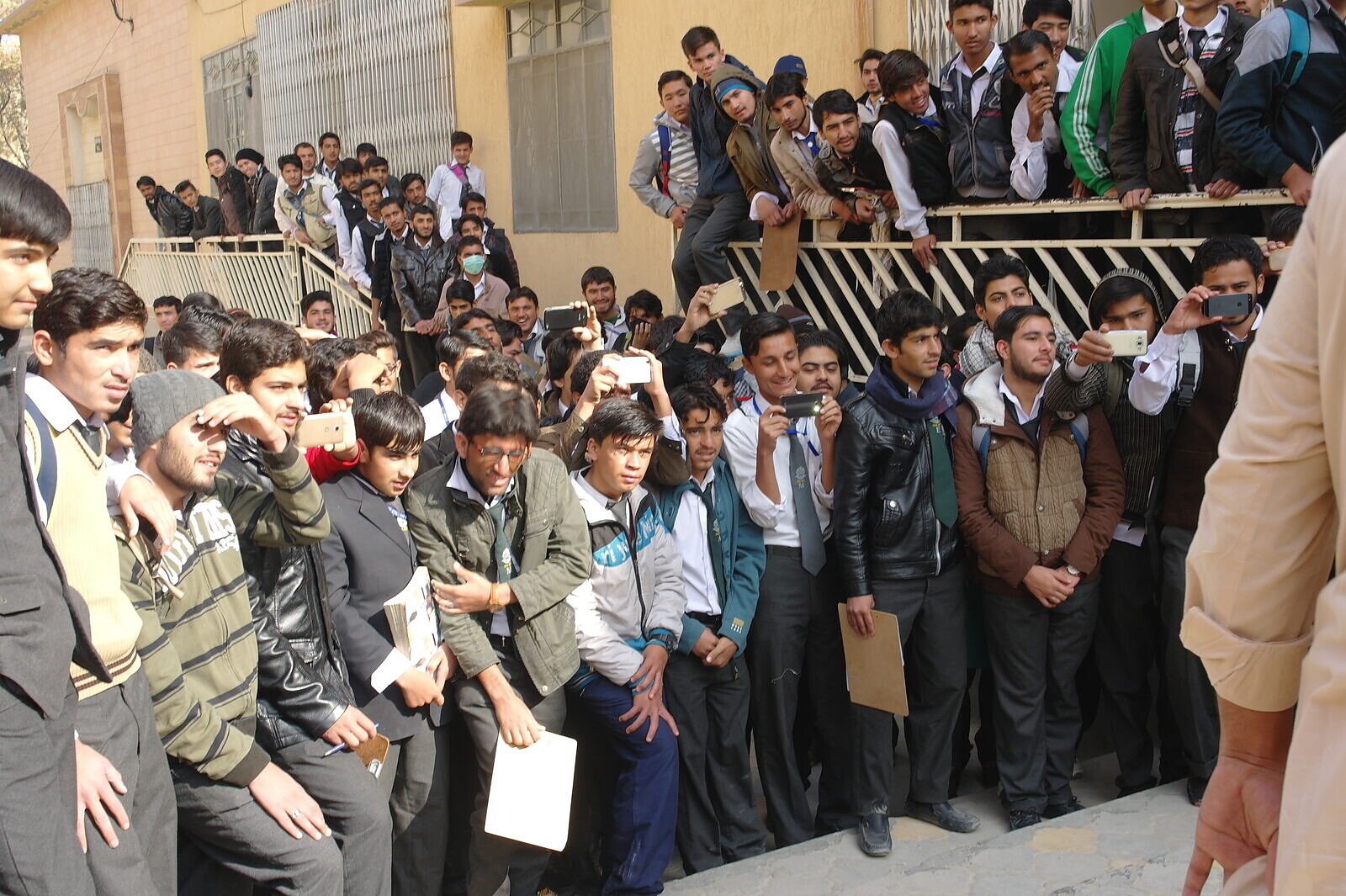 A large group of students gathers outside school