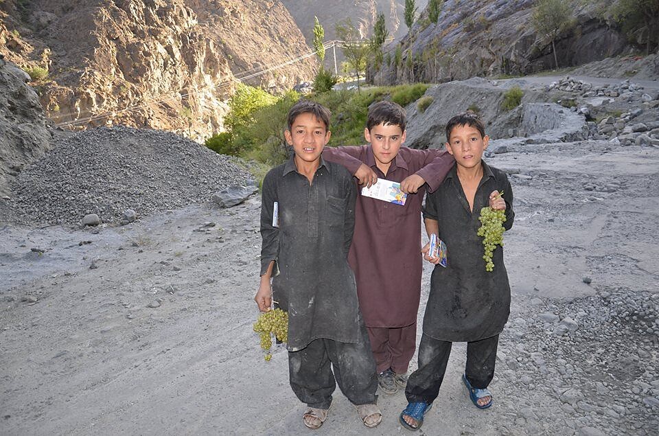 Children sharing a moment on a mountain road
